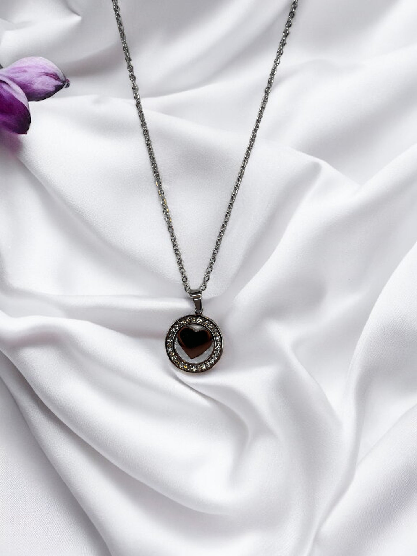 Presenting our Sparkle Heart Necklace – where elegance meets timeless charm. This necklace features a stainless steel composition with a luxurious gold finish, offering enduring beauty and resilience. At its center is a captivating heart, encased within a circle of shimmering cubic zirconia stones that catch the light with every movement. 