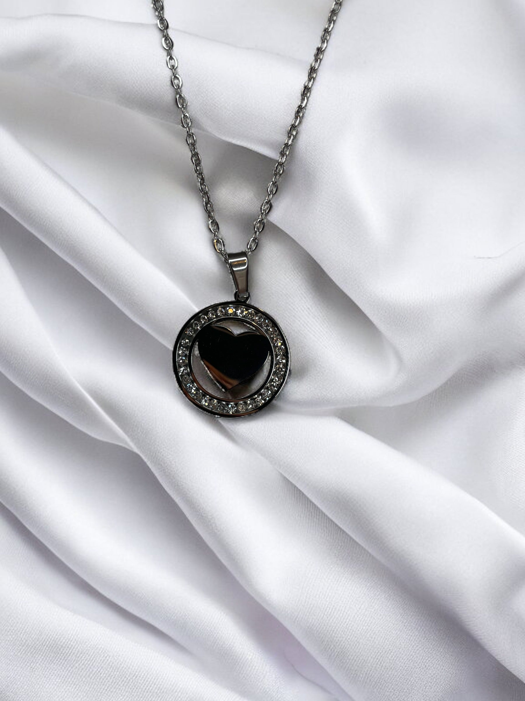 Presenting our Sparkle Heart Necklace – where elegance meets timeless charm. This necklace features a stainless steel composition with a luxurious gold finish, offering enduring beauty and resilience. At its center is a captivating heart, encased within a circle of shimmering cubic zirconia stones that catch the light with every movement. 