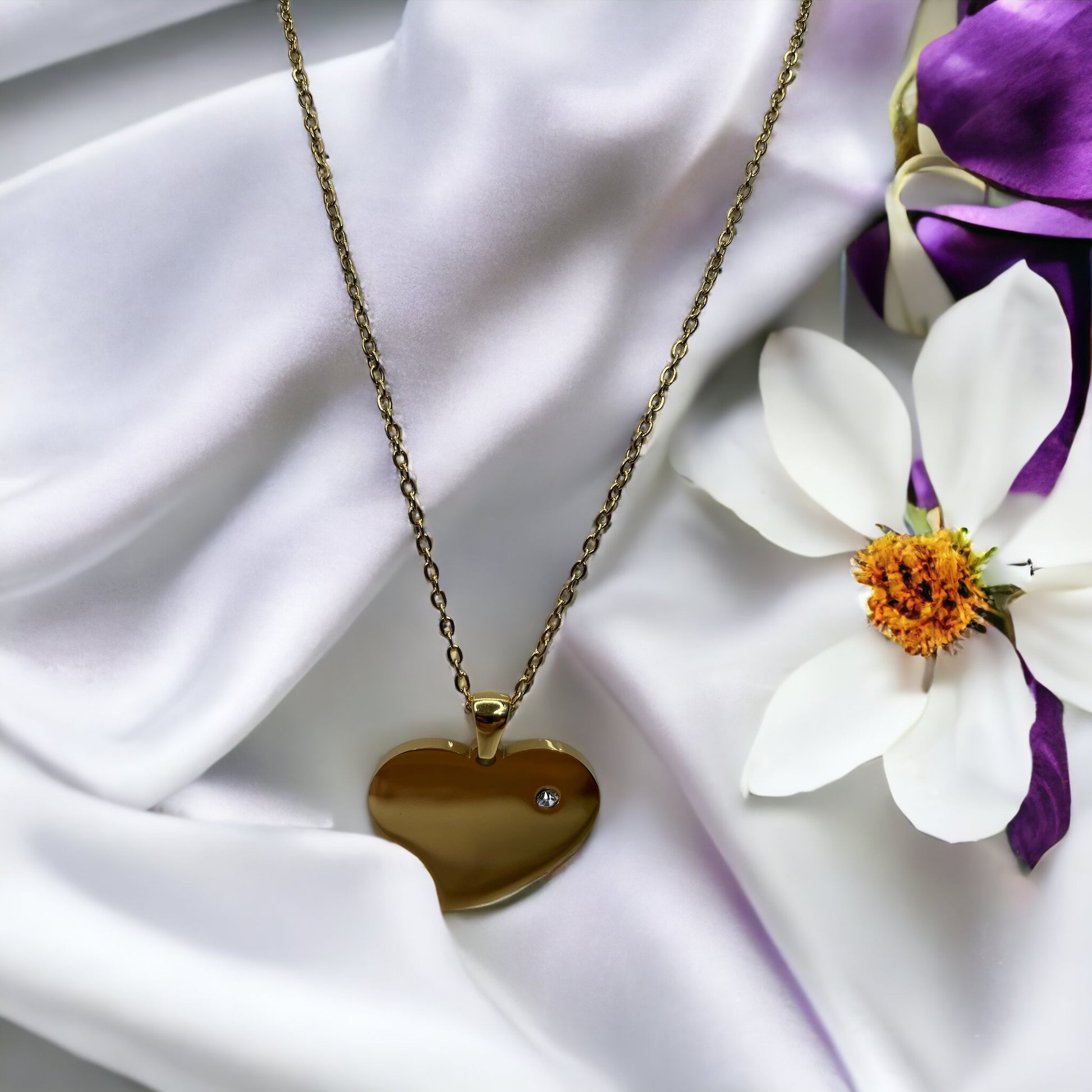 Introducing our Roseline Heart Necklace – a modern twist on a timeless symbol of love. This necklace features a minimalist heart pendant with a smooth, mirror-like finish in gold, offering a chic and sophisticated look. The heart is accentuated with a single, sparkling cubic zirconia, adding just the right amount of brilliance.