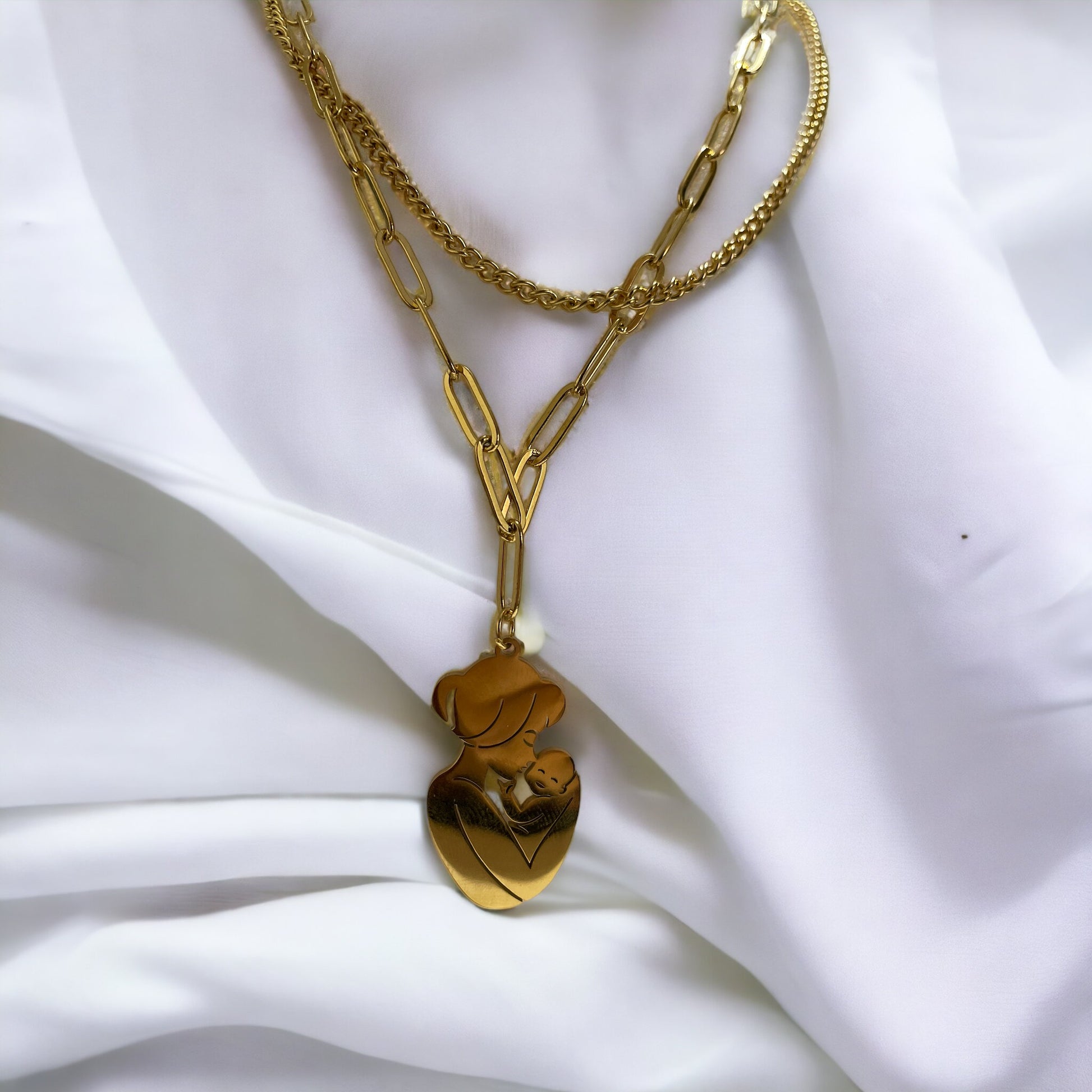 The Maternal Grace Pendant Necklace features a sophisticated design with a mother and her baby in a gentle embrace, forming an abstract heart shape within the pendant. Depending on your selection, the pendant comes in the resilient sheen of stainless steel or the timeless elegance of gold plating. The accompanying chain is tastefully designed to complement the pendant, making the necklace a graceful statement of motherly love and tenderness.