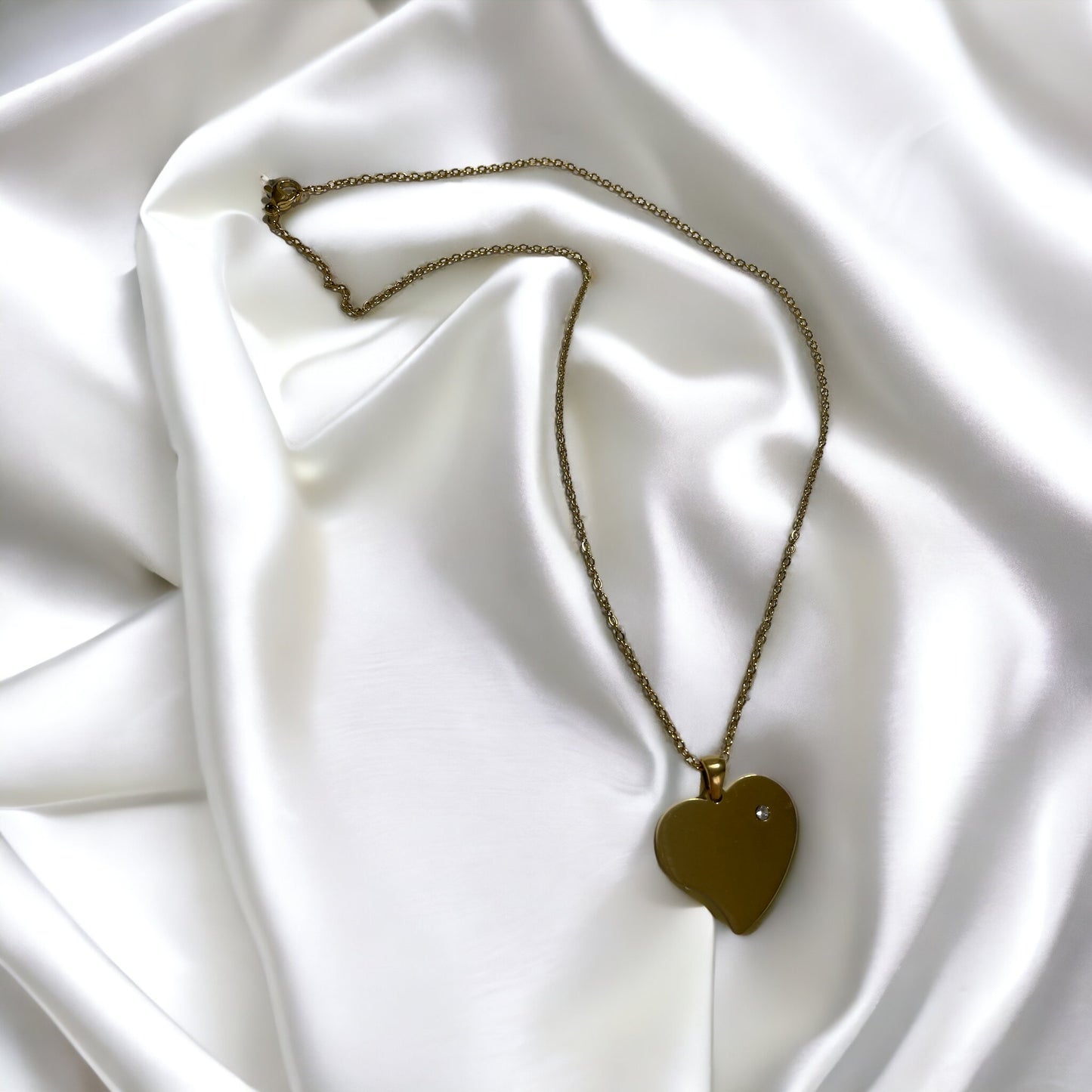 Introducing our Roseline Heart Necklace – a modern twist on a timeless symbol of love. This necklace features a minimalist heart pendant with a smooth, mirror-like finish in gold, offering a chic and sophisticated look. The heart is accentuated with a single, sparkling cubic zirconia, adding just the right amount of brilliance.