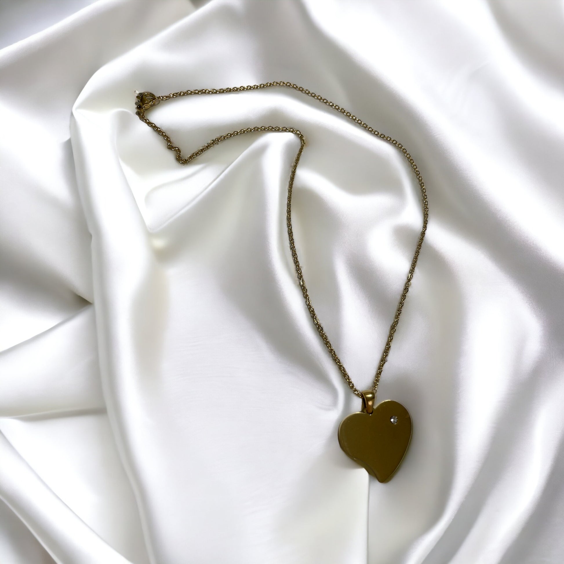 Introducing our Roseline Heart Necklace – a modern twist on a timeless symbol of love. This necklace features a minimalist heart pendant with a smooth, mirror-like finish in gold, offering a chic and sophisticated look. The heart is accentuated with a single, sparkling cubic zirconia, adding just the right amount of brilliance.
