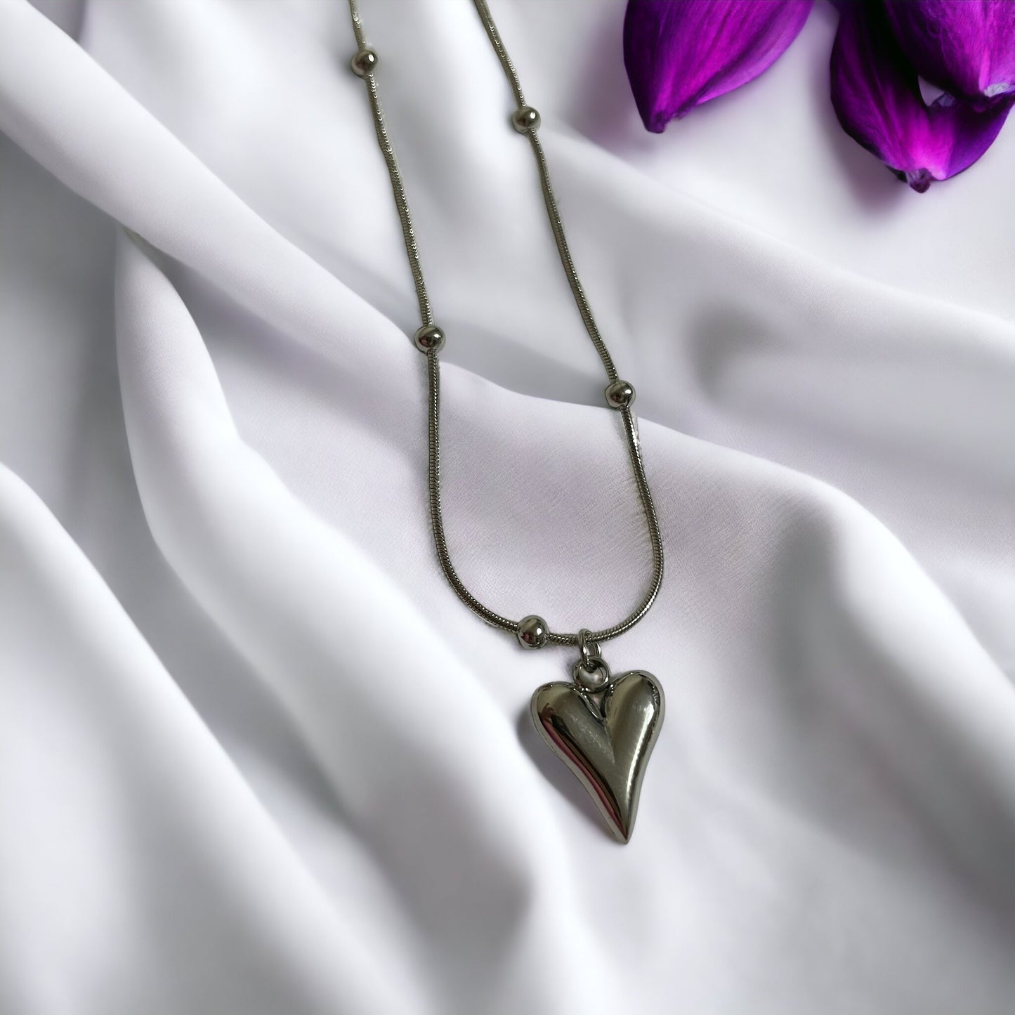 Introducing our Golden Heart Necklace – a modern twist on classic love. This exquisite piece is fashioned from premium stainless steel with a gleaming gold finish, offering both durability and a touch of sophistication. The heart-shaped pendant is polished to a mirror shine, hanging gracefully from a delicate chain adorned with spherical accents.