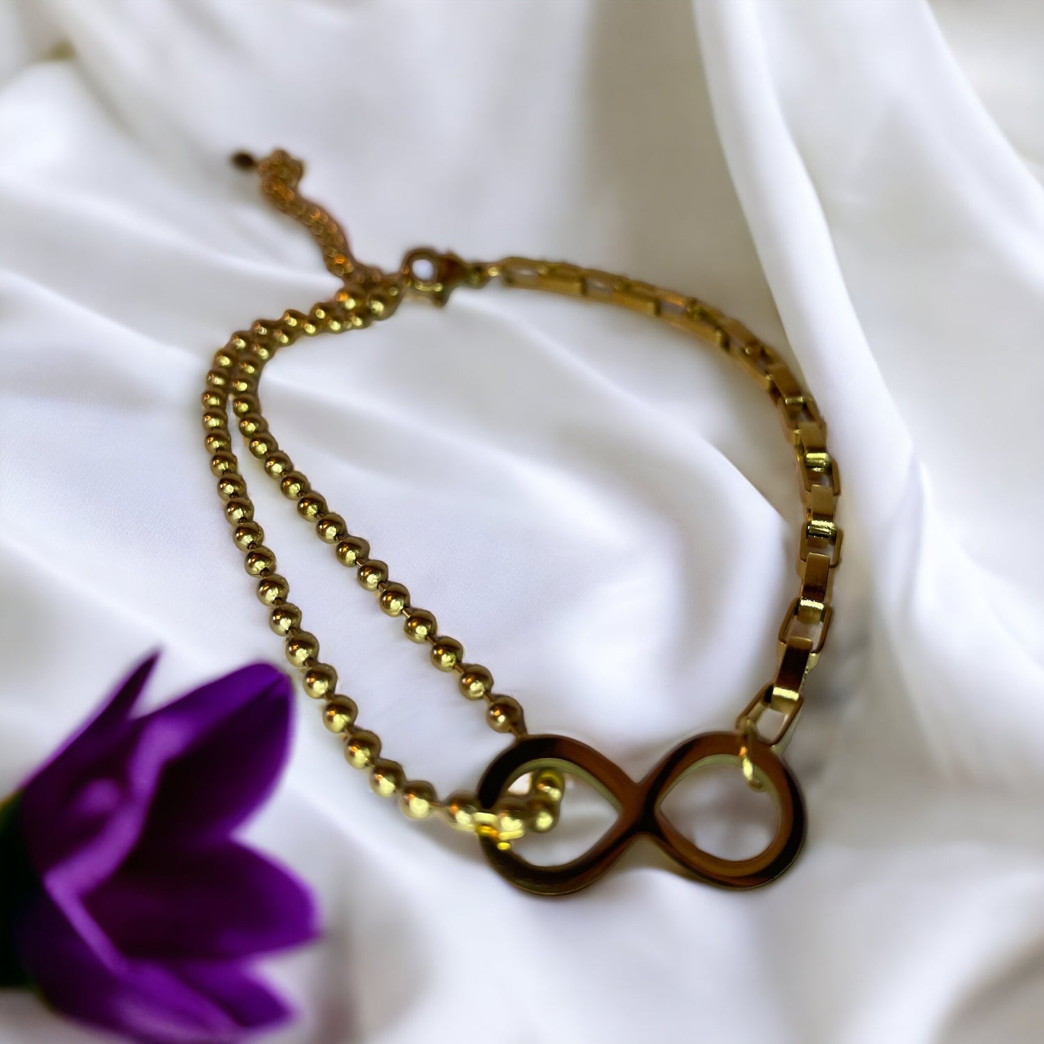 The bracelet seamlessly blends spherical beads with sleek, rectangular links, creating a harmonious balance of shapes and textures. Its gold-plated finish gives it a warm, inviting glow, capturing the eye and symbolizing a connection that lasts forever. This bracelet is also available in a stainless steel variant, offering durability along with its timeless elegance.