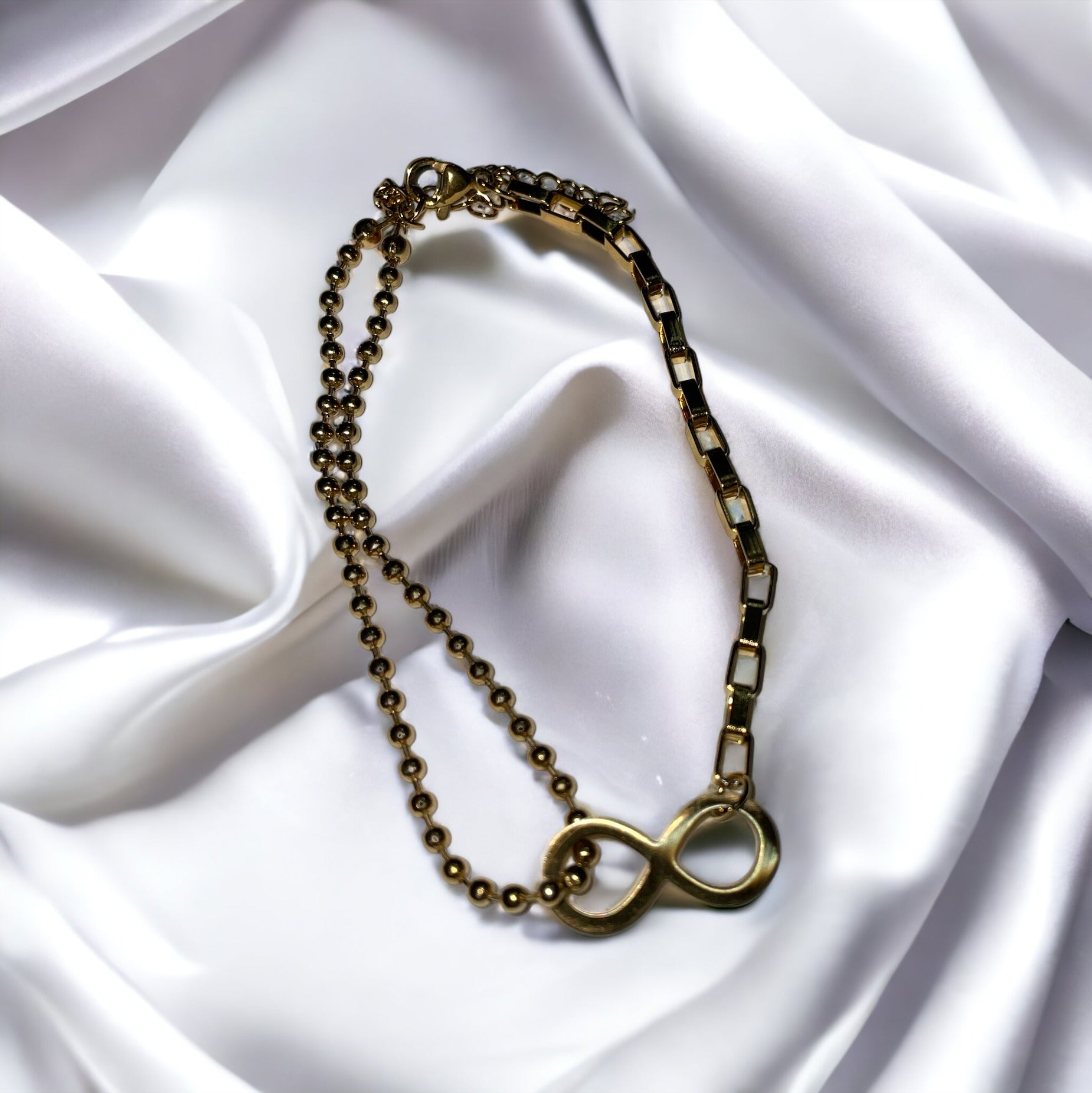 The bracelet seamlessly blends spherical beads with sleek, rectangular links, creating a harmonious balance of shapes and textures. Its gold-plated finish gives it a warm, inviting glow, capturing the eye and symbolizing a connection that lasts forever. This bracelet is also available in a stainless steel variant, offering durability along with its timeless elegance.