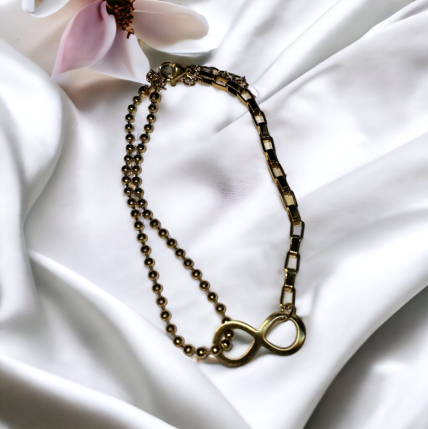 The bracelet seamlessly blends spherical beads with sleek, rectangular links, creating a harmonious balance of shapes and textures. Its gold-plated finish gives it a warm, inviting glow, capturing the eye and symbolizing a connection that lasts forever. This bracelet is also available in a stainless steel variant, offering durability along with its timeless elegance.
